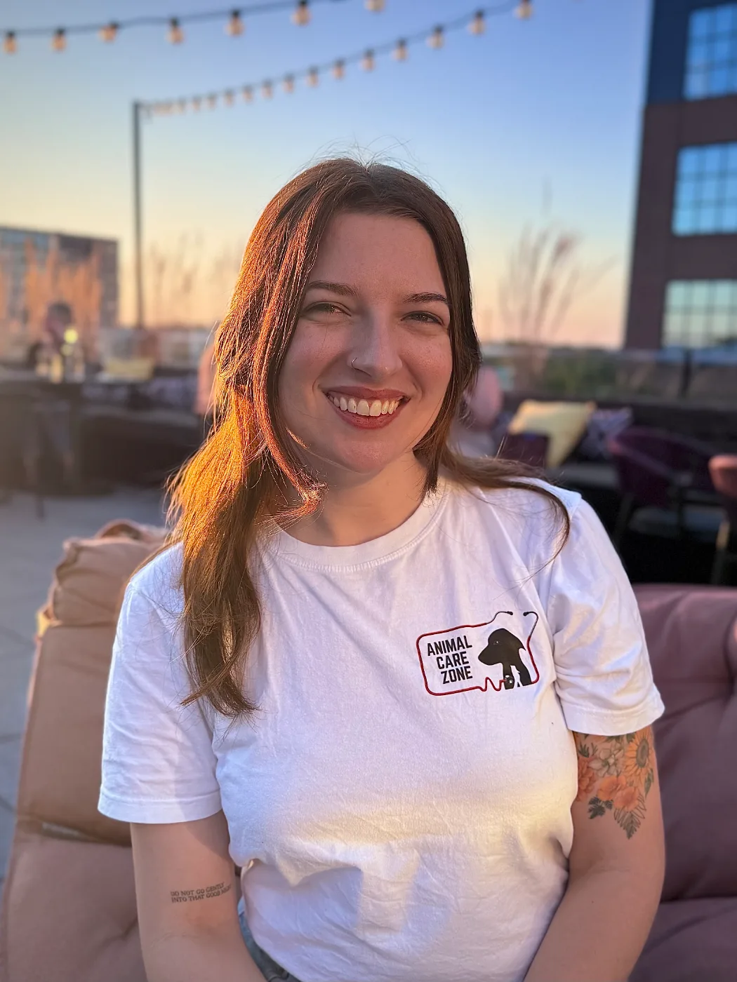 Abby in an Animal Care Zone T-shirt at a rooftop event at sunset